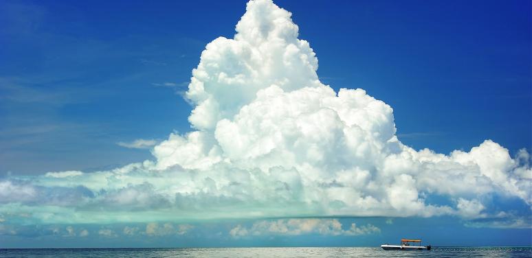 a large cloud is seen above a large body of water