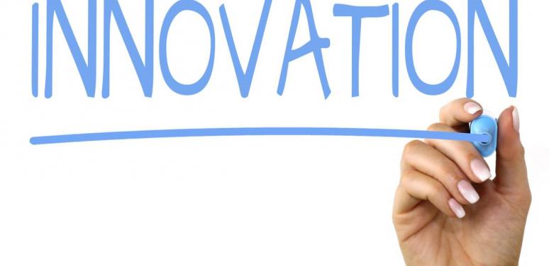 a hand with a marker writing the word 'innovation'
