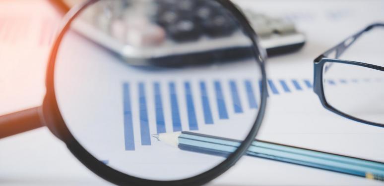 magnifying glass over a table of data.