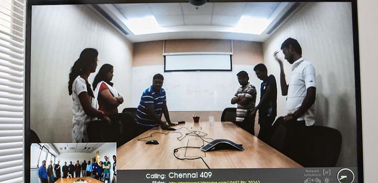 poeple at a video conference around a desk