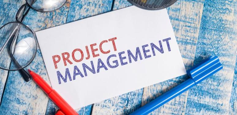 paper that reads "project management" next to glasses and pens
