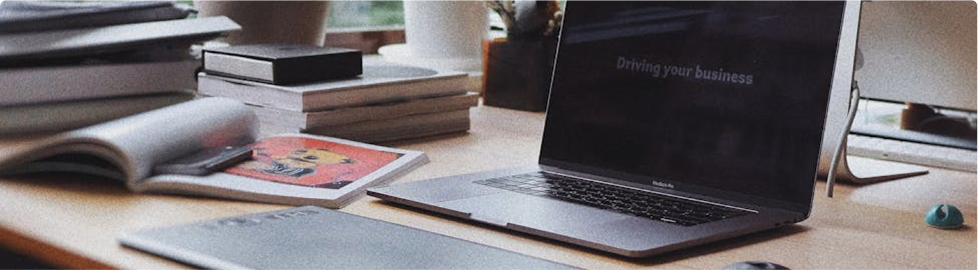 a computer on a desk surrounded by books and paperwork