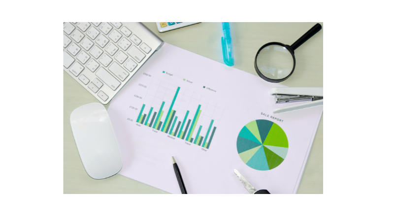 Desk with keyboard and paper with bar and circle graph